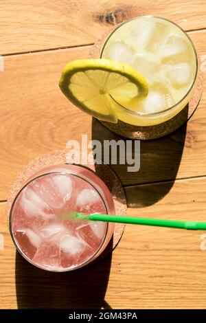 Vertikale Aufnahme von Zitronen- und Grapefruitsaft von oben mit Schatten von Sonnenschein Stockfoto