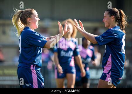 Sophie Manzi (L) und Kapitän Brit Saylor (R) gehen nach dem Tor zum Eröffnungsspiel der Saison 21/22 in Champio beim FC Dulwich Hamlet Women in die High-Five-Saison Stockfoto