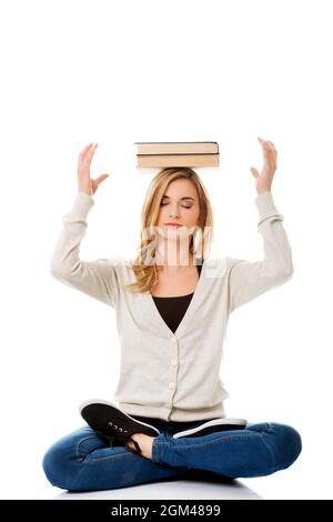Kaukasische blonde Frau aus Polen mit Büchern auf dem Kopf auf weißem Hintergrund Stockfoto