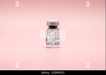 COVID-19-Impfstoff. Glasfläschchen vor rosa Hintergrund. MRNA-Impfstoff gegen das Coronavirus (SARS-CoV-2). Stockfoto