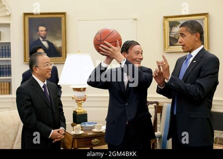 Der chinesische Vizepremierminister Wang Qishan, Mitte, hält den Basketball, den ihm Präsident Barack Obama nach seinem Treffen des Oval Office am Dienstag, dem 28. Juli 2009, gegeben hat, um die Ergebnisse des ersten strategischen und wirtschaftlichen Dialogs zwischen den USA und China zu diskutieren. Auf der linken Seite sieht der chinesische Staatsrat Dai Bingguo. (Offizielles Foto des Weißen Hauses von Pete Souza) Dieses offizielle Foto des Weißen Hauses wird zur Veröffentlichung durch Nachrichtenorganisationen und/oder zum persönlichen Druck durch die Betreffzeile(en) des Fotos zur Verfügung gestellt. Das Foto darf in keiner Weise manipuliert oder in Materialien oder Anzeigen verwendet werden Stockfoto