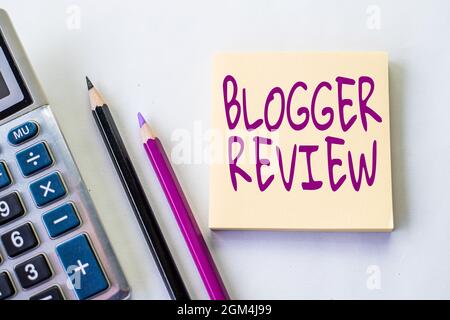 Hand schreiben Zeichen Blogger Review. Geschäftsansatz eine kritische Neuüberlegung und Zusammenfassung eines Blogs Plain Spiral Notebook mit Stift daneben Stockfoto