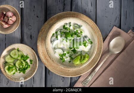 Indische Raita-Sauce mit Kräutern und Gurke. Auf einem Holztisch. Selektiver Fokus. Stockfoto