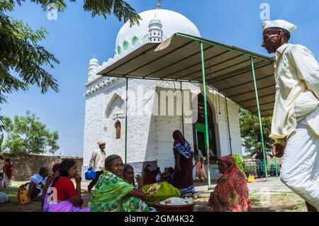 Bijapur, Karnataka, Indien : Pilger sitzen am Pilgerort Jod Gumbad aus dem 17. Jahrhundert. Stockfoto