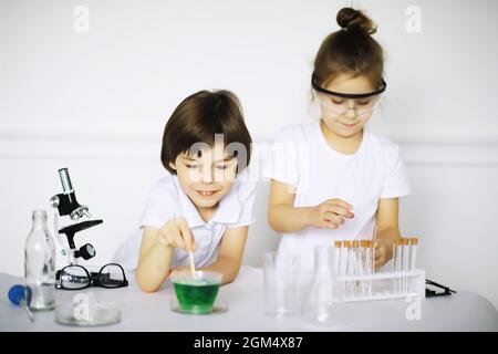 Zwei niedliche Kinder am Chemieunterricht machen Experimente isoliert auf weißem Hintergrund Stockfoto