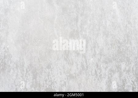 Alte, bemalte, betongraue Wand aus der Nähe, abblätternder Putz. Risse auf der Oberfläche. Vintage-Hintergrund, Kopierbereich Stockfoto