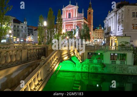 Preseren Platz mit Tromostovje Brücke auf dem Fluss Ljubljanica in der Nacht mit Stadtlichtern in Slowenien Ljubjana mit Cerkev Marijinega oznanjenja Kirche Stockfoto