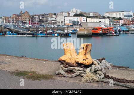 Ramsgate, Großbritannien - Sep 9 2021 Ein rostfreier orangefarbener Poller mit Kette und Seil im Ramsgate Royal Harbour. Stockfoto