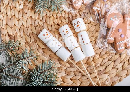 Schneemänner aus weichen Sumpflaibchen auf Weidenmatte Stockfoto