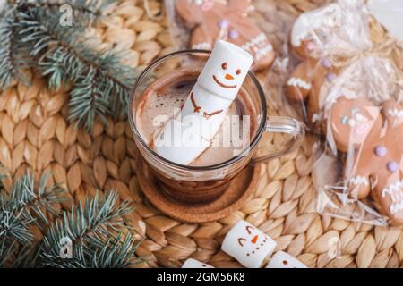 Schneemann aus weichen Marshallows und eine Tasse heiße Schokolade auf dem Tisch Stockfoto