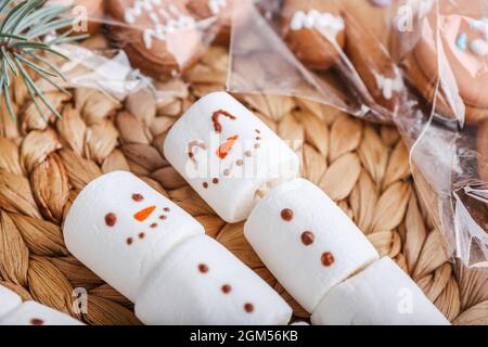 Schneemänner aus weichen Sumpflaibchen auf Korbmatte, Nahaufnahme Stockfoto