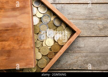 Schachtel mit Münzen auf Holzhintergrund Stockfoto