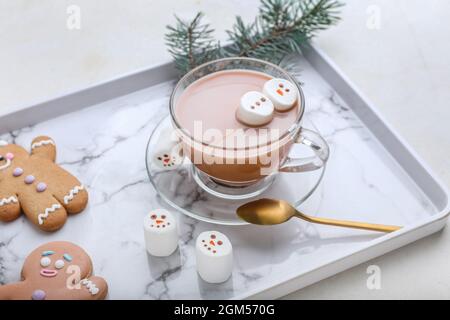 Tablett mit Schneemann aus weichen Marshallows und Tasse heiße Schokolade auf weißem Hintergrund Stockfoto