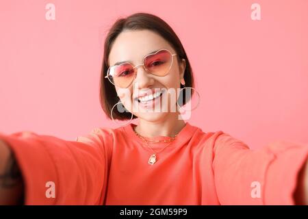 Schöne junge Frau auf rosa Hintergrund Stockfoto