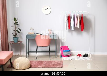Stilvolle Schuluniform und Rucksack im Innenraum des Raumes Stockfoto