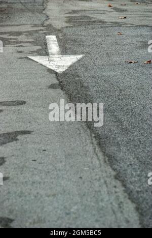 Vertikale Aufnahme des Transports Zeichen ein weißer Pfeil auf dem Boden in der Straße Stockfoto