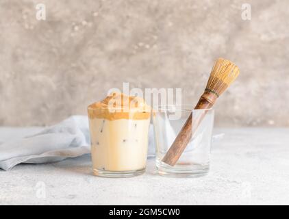 Ein Glas schmackhafter dalgona hojicha und Chasen auf dem Tisch Stockfoto