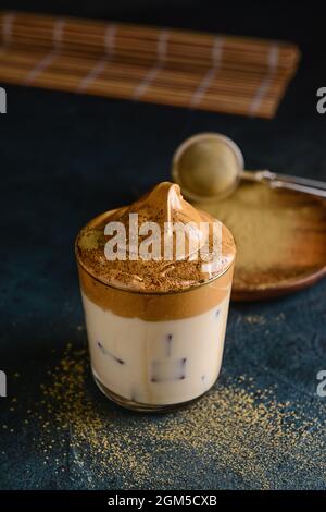 Ein Glas schmackhaften dalgona hojicha auf dunklem Grund Stockfoto