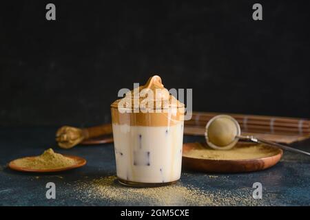 Ein Glas schmackhaften dalgona hojicha auf dunklem Grund Stockfoto