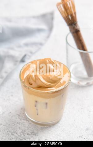 Ein Glas schmackhaften dalgona hojicha auf hellem Hintergrund Stockfoto