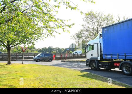 Ein Containerwagen verlässt die M27-Tankstelle Rownhams in der Nähe von Southampton England, um die Fahrt auf der Autobahn M27 zu fortsetzen. Stockfoto