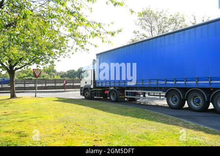 Ein Containerwagen verlässt die M27-Tankstelle Rownhams in der Nähe von Southampton England, um die Fahrt auf der Autobahn M27 zu fortsetzen. Stockfoto