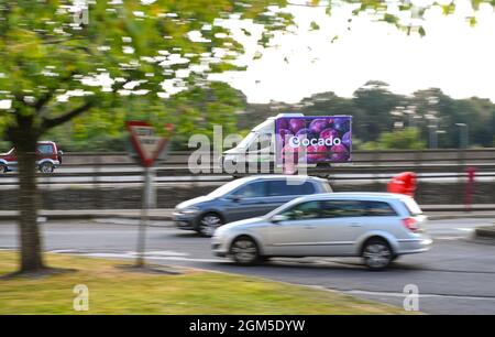Ocado Lebensmittel Lieferwagen fährt auf der Autobahn M27 nach der Lieferung in Schwenk geschossen zwischen Autos mit Kopieplatz gezeigt. Stockfoto