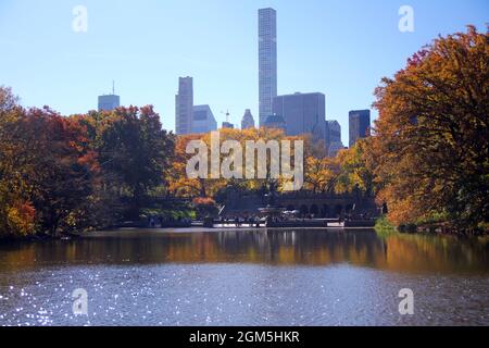 Im Central Park mit dem See und den Wolkenkratzern auf der Rückseite in New York City können Sie die Blätter der Bäume bewundern Stockfoto