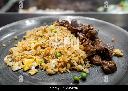 Ein Teller mit gebratenen Hibachi-Gemüsereis mit Huhn und Steak. Stockfoto