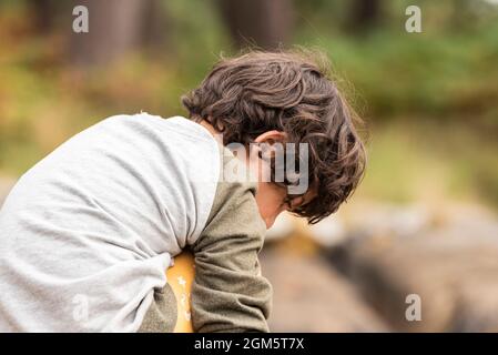 Portrait während der Reise von weißen kaukasischen Mädchen mit kurzen Haaren. Mit Klippe und Wald im Hintergrund. Stockfoto