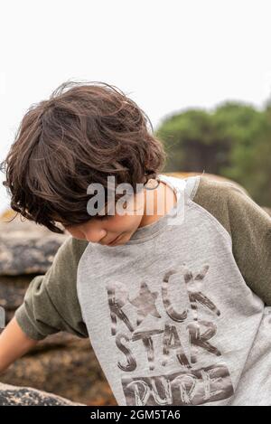 Portrait während der Reise von weißen kaukasischen Mädchen mit kurzen Haaren. Mit Klippe und Wald im Hintergrund. Stockfoto