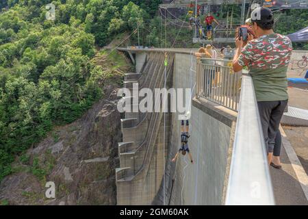 Verzasca, Schweiz - 2021. Juni: Menschen am Bungee-Jumping des Verzasca-Staudamms am Vogorno-See in der Schweiz. Drehort von James Bond-Filmen im Tessin Stockfoto