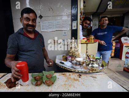 Vorbereitung der asiatischen Paan-An / südasiatischen kauen stimulierende aus ein Betelblatt mit zerkleinerten Areca-Nuss und Gewürzen innen hergestellt. Stockfoto