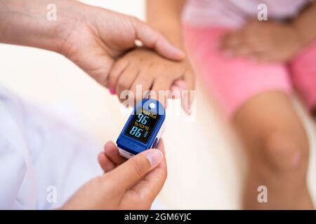 Arzt Überprüft Den Kindliche Blutpuls Mit Dem Oximeter Stockfoto