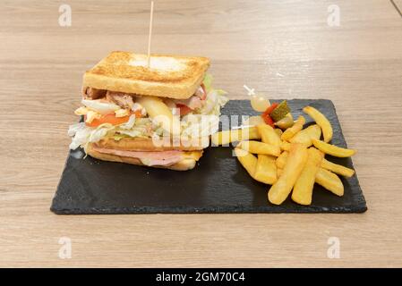 Gemischtes Sandwich mit Salat, Thunfischkonserven, weißem Spargel, gekochtem Ei, Schinken und Käse mit gegrilltem Brot, garniert mit Bratkartoffeln und würzigem Bander Stockfoto