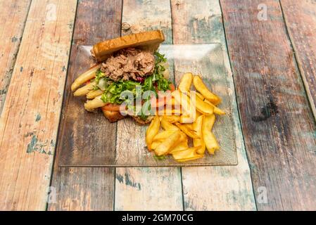 Brioche-Brot-Sandwich mit viel weißem Spargel aus der Dose, Bonito del norte aus der Dose, Escarole und Rucola, Tomaten und Spiegelei und garniert mit Hom Stockfoto