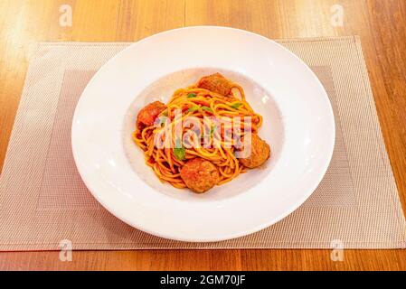 Italienisches Rezept mit Spaghetti mit Pomodoro-Sauce und Hackbraten, mit frischem Basilikum auf der Oberseite geschmort Stockfoto