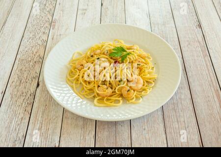 Spaghetti mit Meeresfrüchten, sautierten Garnelen, Cayenne und roher Petersilie auf einem weißen Teller Stockfoto