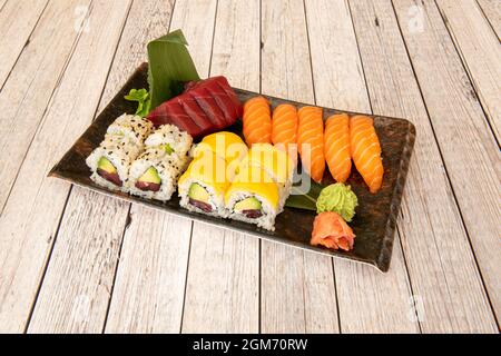 Super sortiertes Sushi-Tablett mit norwegischem Lachs Nigiri, rotem Thunfisch-Sashimi, Uramaki california Roll mit reifer Avocado mit Nori-Algen und Scheiben AF Stockfoto