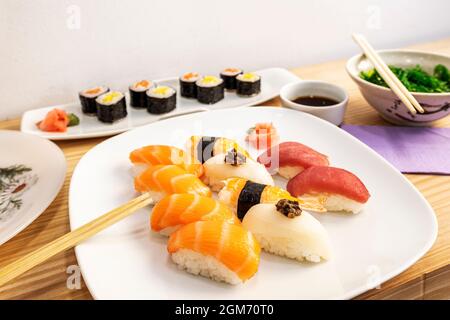 Nigiri Sushi-Tablett mit ebi, Garnelen, Japanisch, Reis mit Essig, norwegischem Lachs und rotem Thunfisch, Butterfisch, Wakame-Salat und Sojasauce mit m Stockfoto