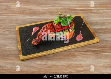 Tandoori murgh Rezept geröstete Hühnerschenkel mit Spinatsalat, rote Zwiebel Stockfoto