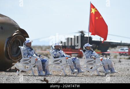 Dongfeng Landing Site. September 2021. Die Astronauten nie Haisheng (C), Liu Boring (R) und Tang Hongbo befinden sich am 17. September 2021 auf dem Landeplatz Dongfeng in der Autonomen Region Innere Mongolei im Norden Chinas aus der Rückkapsel des Raumschiffs Shenzhou-12. Drei chinesische Astronauten, die ersten, die für den Bau von Raumstationen in die Umlaufbahn geschickt wurden, haben ihre dreimonatige Mission abgeschlossen und sind am Freitag sicher zur Erde zurückgekehrt. Quelle: Lian Zhen/Xinhua/Alamy Live News Stockfoto