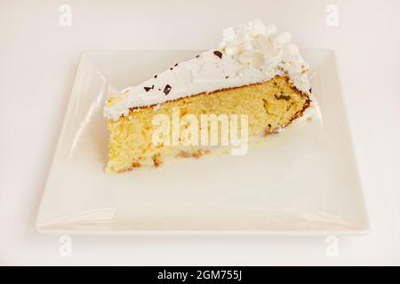 Zitronentorte mit Biskuitkuchen und Creme und weißem Schokoladensirup Stockfoto