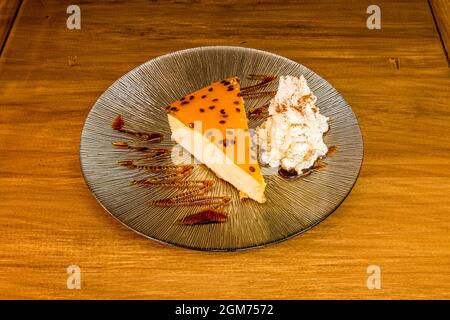 Passionsfruchttrank mit Käse und Schlagsahne mit Karamellsirup auf einer Glasplatte Stockfoto