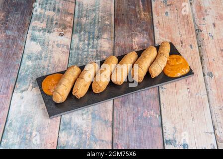 Venezolanisches beliebtes Rezept von tequeños gefüllt mit frischem Käse und Sauce zum Eintauchen Stockfoto