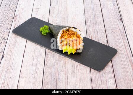 Temaki-Sushi mit norwegischem Lachs, reifen mexikanischen Avocado, knusprigen Zwiebeln und weißem Reis mit Essig und Nori-Algen-Kegel Stockfoto