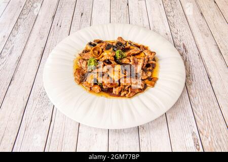 Kalbsrezept mit Gemüse und Pilzen mit Sauce aus anderen chinesischen Rezepten auf weißem Teller Stockfoto