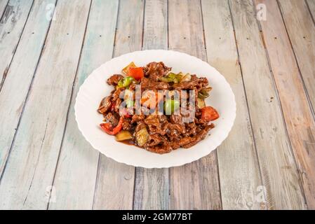 Gericht aus gehacktem und sautiertem Rindfleisch mit Paprika, Zwiebeln und Bambus-Wok mit Austernsauce, zubereitet nach dem Rezept eines chinesischen Küchenchefs Stockfoto