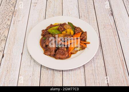 Eintopf aus chinesischem Rindfleisch mit Austernsauce mit Zwiebel, Bambus und Wok-sautiertem Gemüse auf weißem Teller. Stockfoto