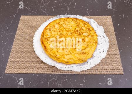 Großartiges spanisches Omelett mit Eiern und Kartoffeln mit Zwiebeln auf einem Gebäckblech mit perforiertem Papier Stockfoto